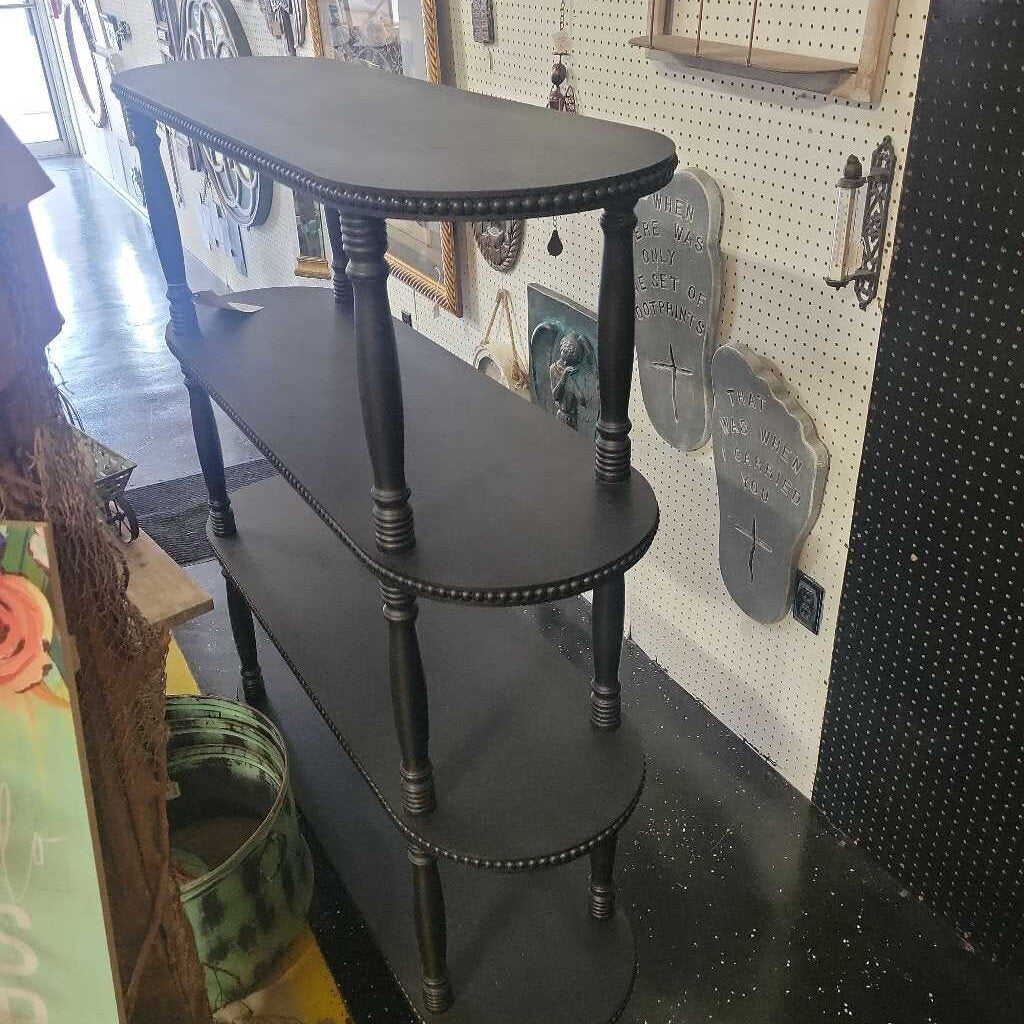 Black wood shelf with four shells